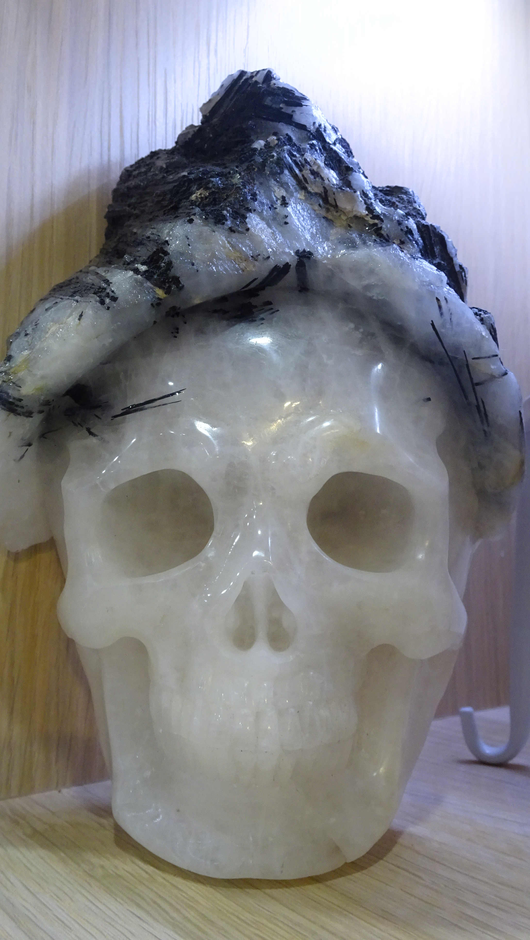 Smiling quartz carved crystal skull with black tourmaline and quartz hat