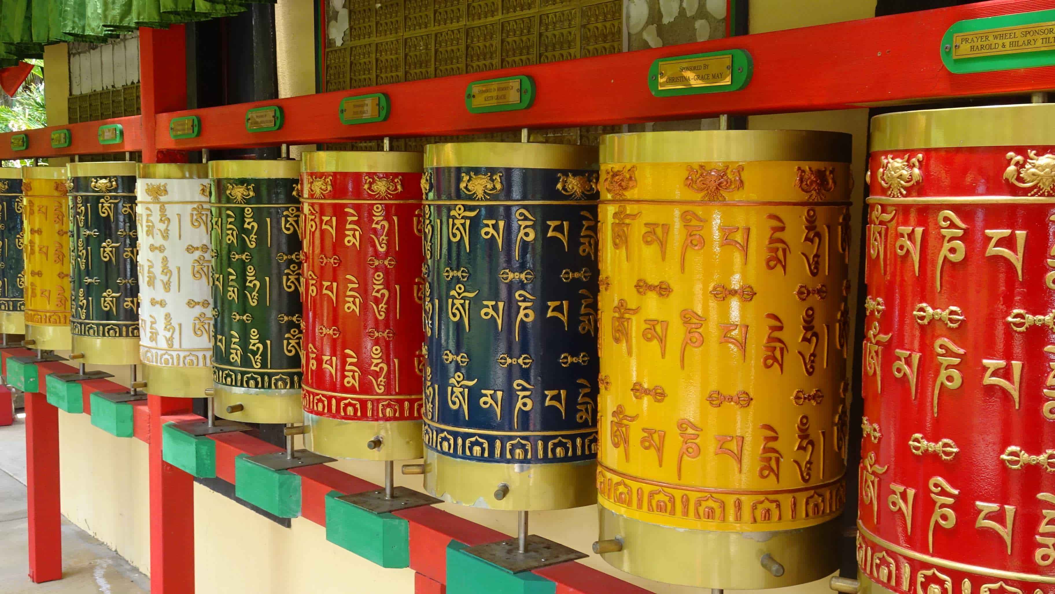 Coloured prayer wheels in a row