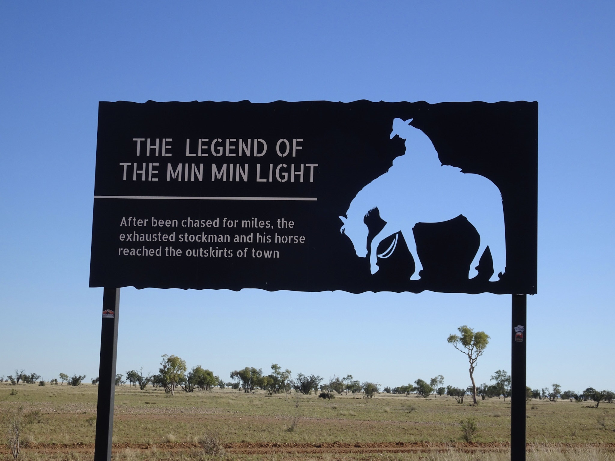 Cut-out metallic signage explaining of The Legend of the Min Min Light with stockman on horse