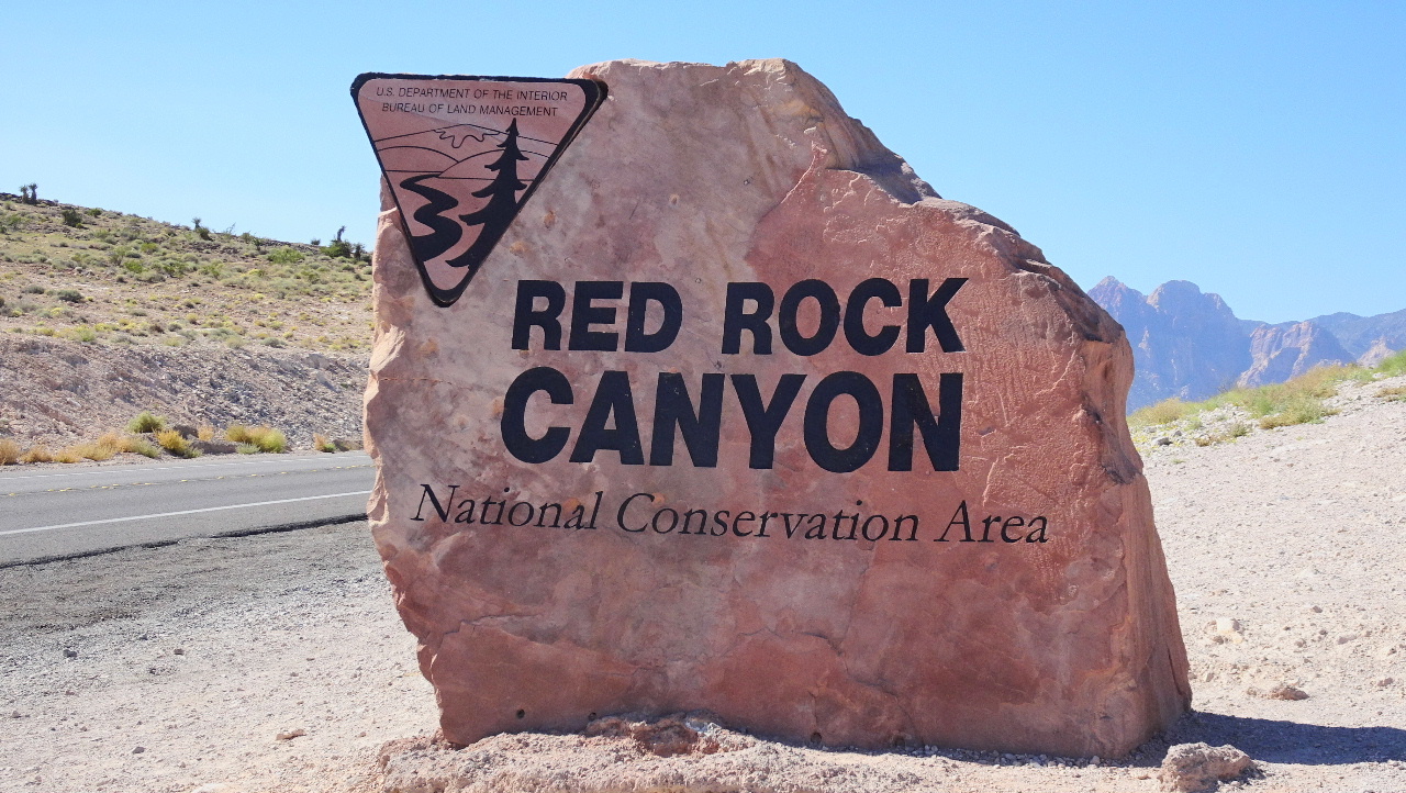 Large rock by side of highway welcoming visitors to Red Rock Canyon, Nevada