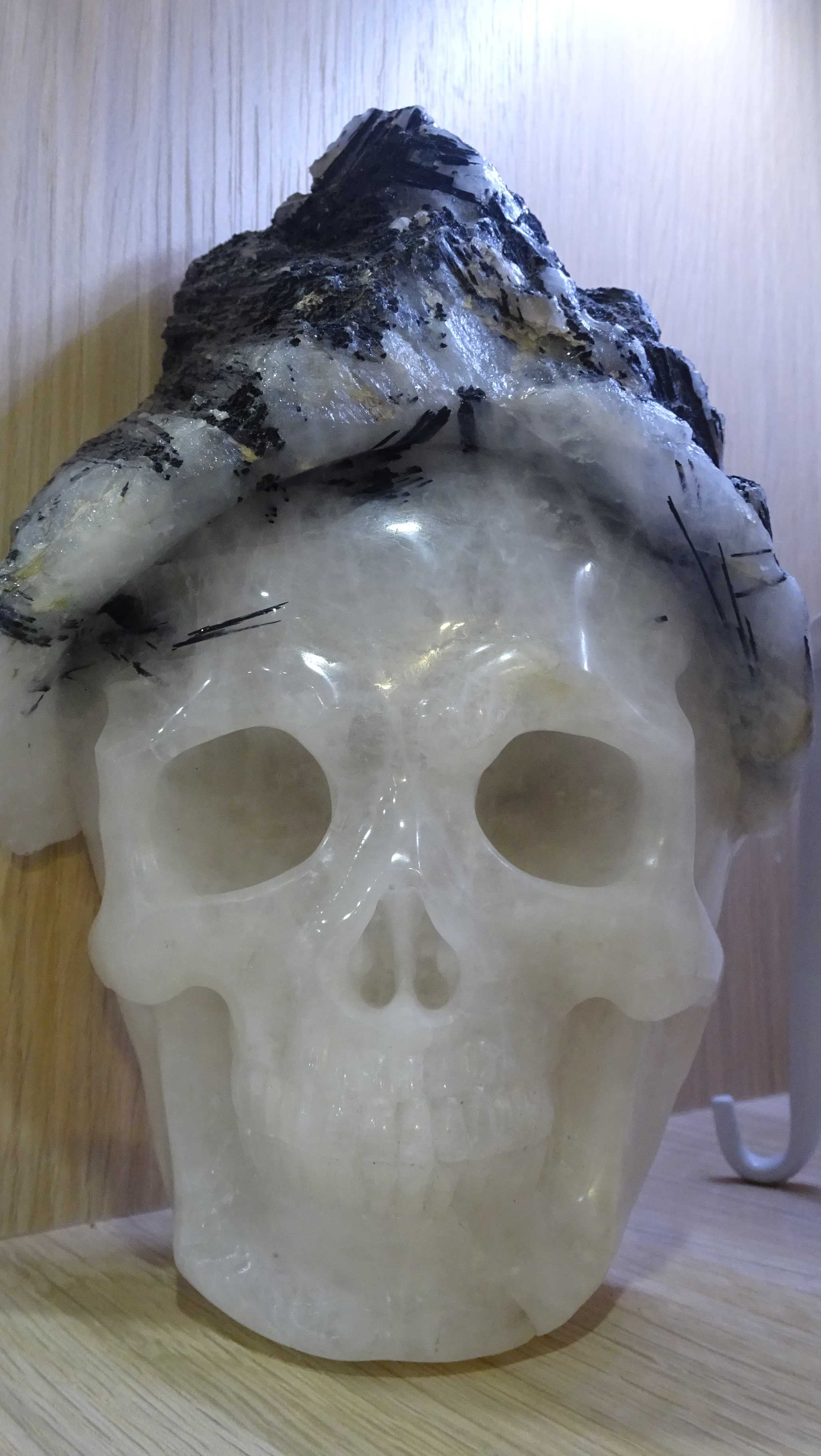 Smiling quartz carved crystal skull with black tourmaline and quartz hat