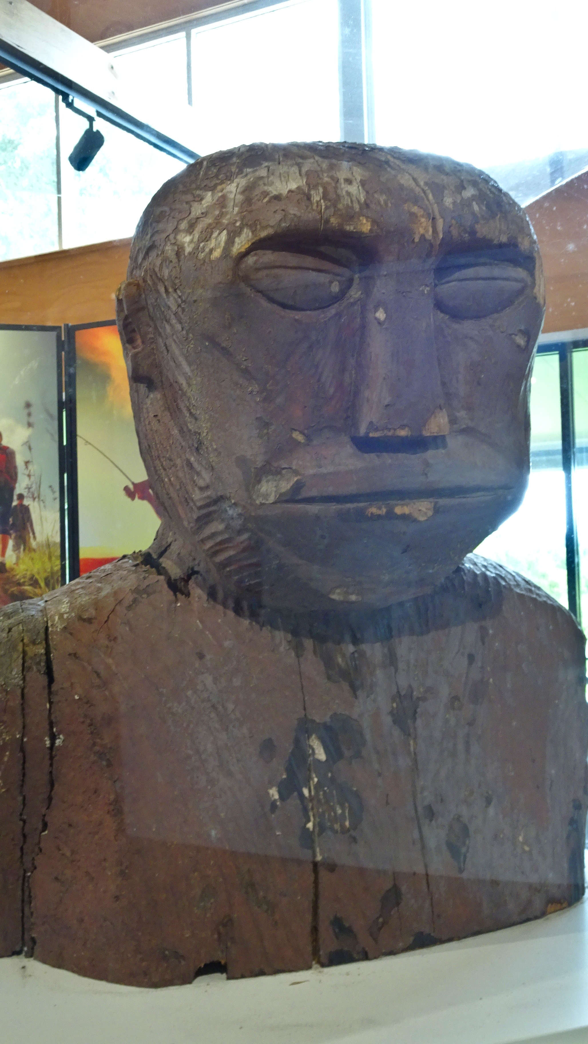 Head of original yowie statue behind glass