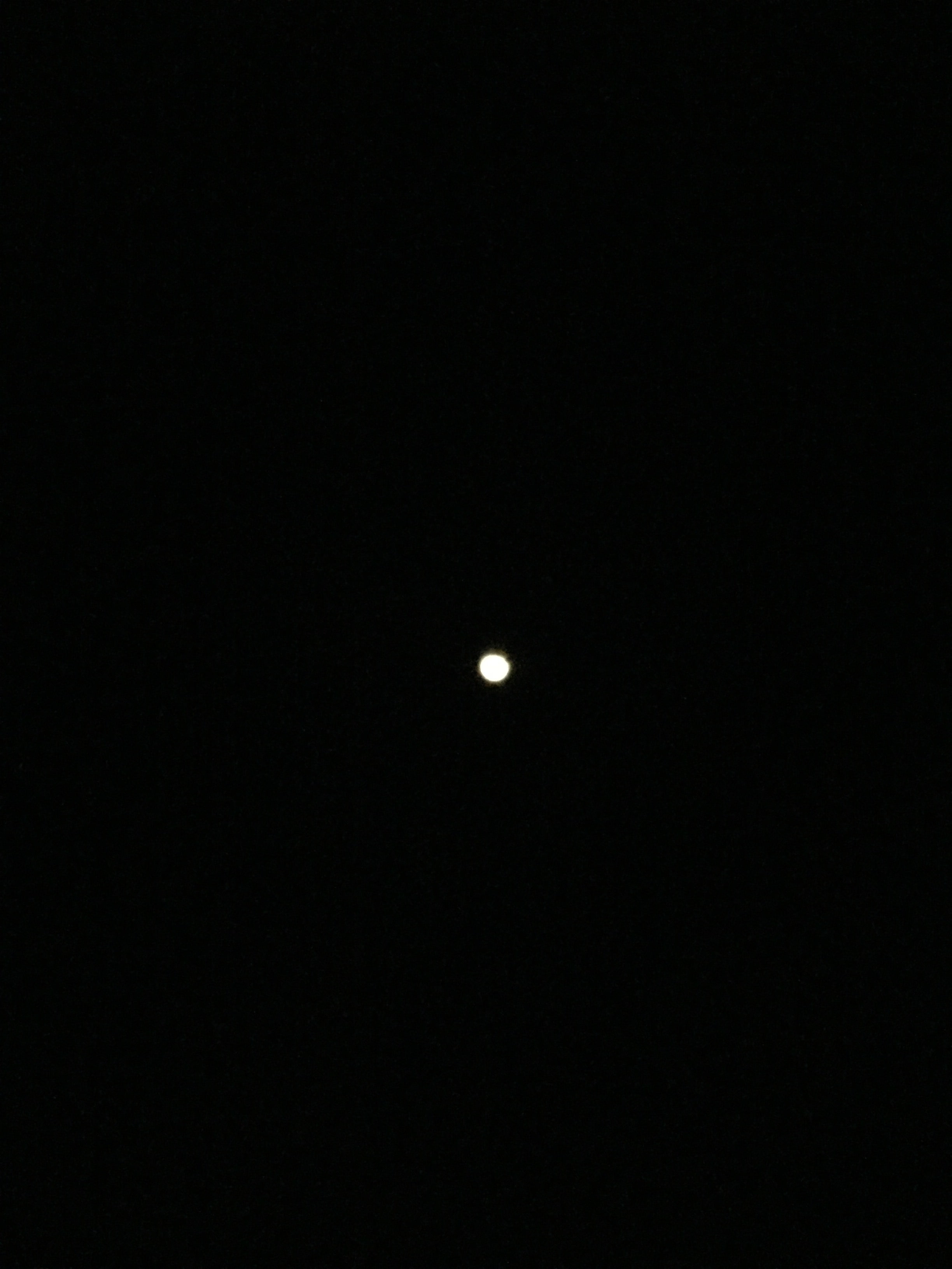 Night-time view of white orb in the sky